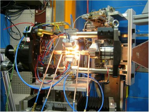 Der installierte Prüfstand mit der Hochtemperatur-Probenumgebung einschließlich vier Heizlampen am Neutronendiffraktometer STRESS-SPEC am MLZ. Der Hitzeschutz ist abmontiert, um einen Einblick in den Aufbau zu ermöglichen. Prüfstand